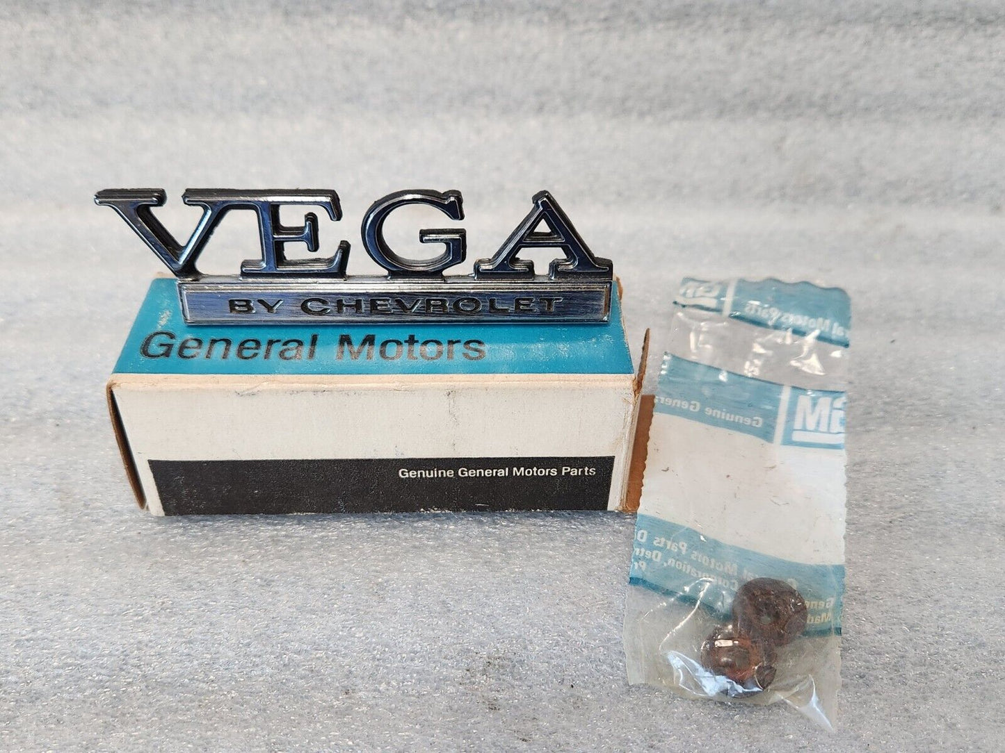 NOS OEM GM 1973-77 Vega Header rear Body Panel Nameplate Emblem 1700895 9633779