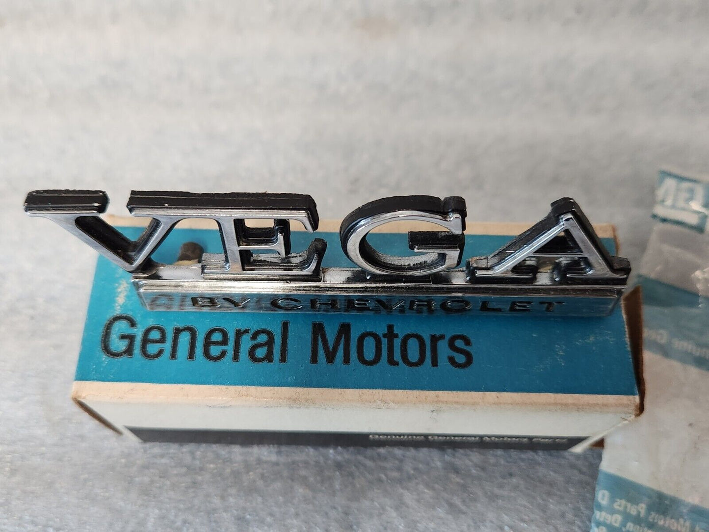 NOS OEM GM 1973-77 Vega Header rear Body Panel Nameplate Emblem 1700895 9633779