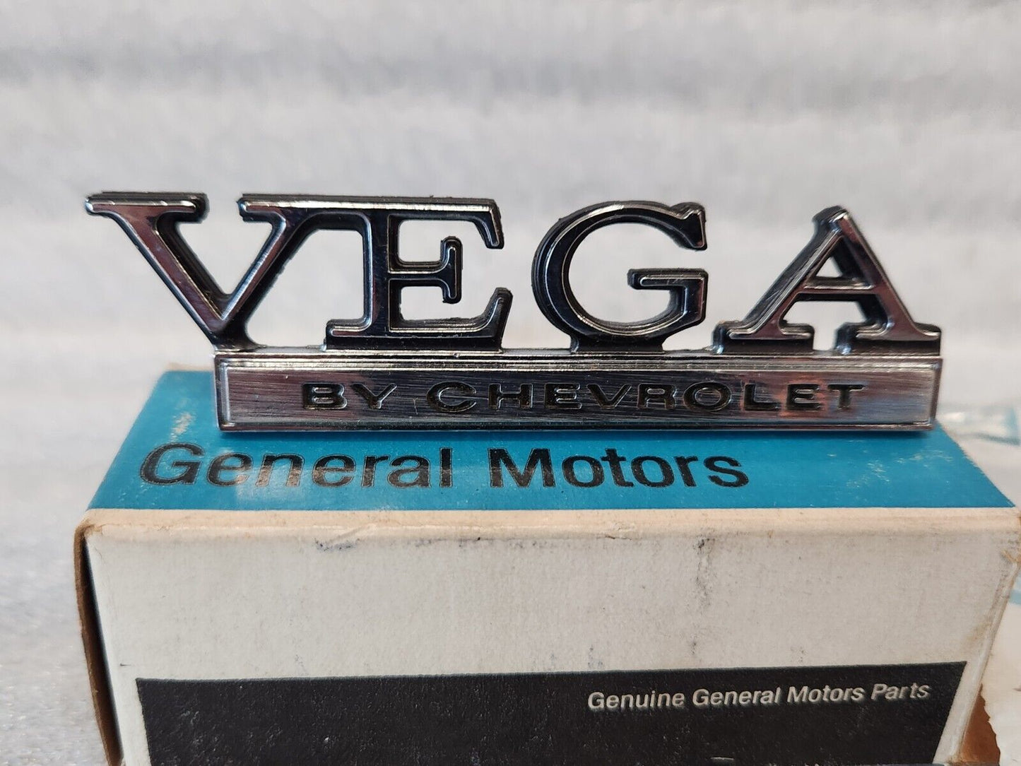 NOS OEM GM 1973-77 Vega Header rear Body Panel Nameplate Emblem 1700895 9633779