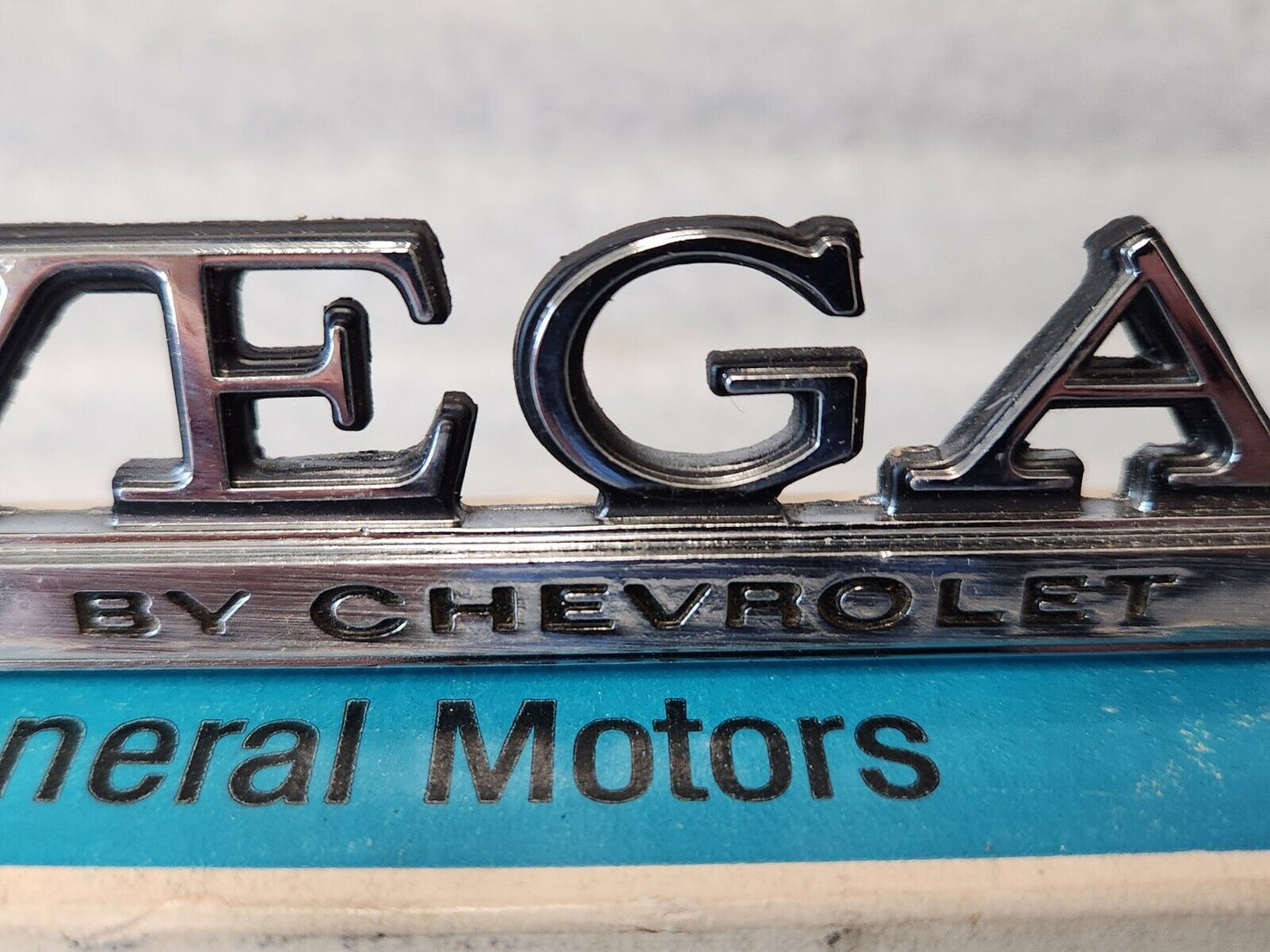 NOS OEM GM 1973-77 Vega Header rear Body Panel Nameplate Emblem 1700895 9633779